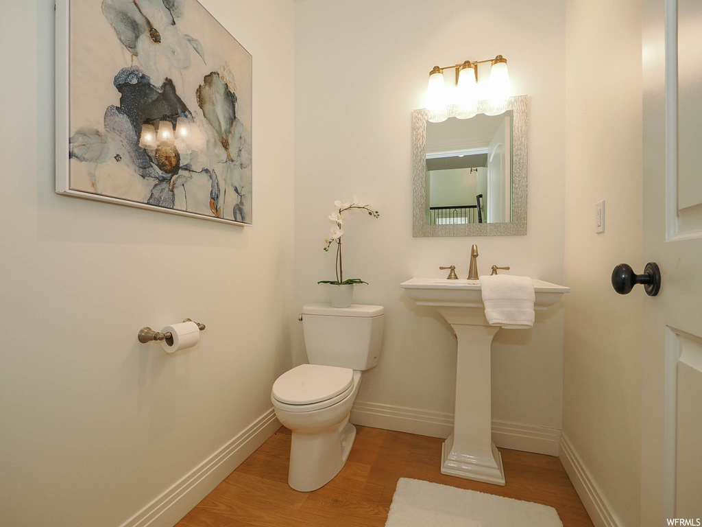 Bathroom with mirror, light hardwood floors, and sink