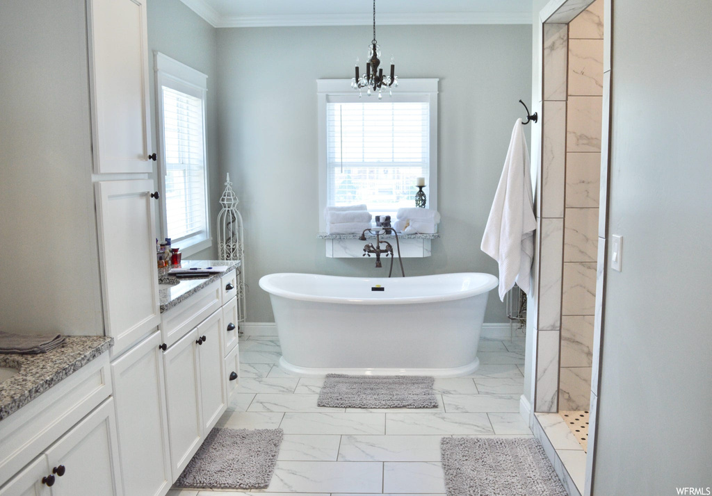 Bathroom featuring crown molding, a wealth of natural light, vanity, light tile floors, and separate shower and tub enclosures