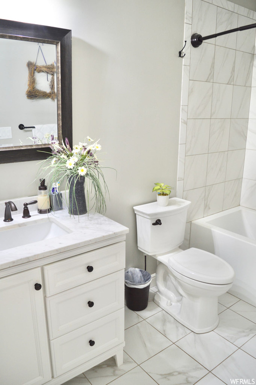 Full bathroom with vanity, tiled shower / bath, mirror, and light tile floors