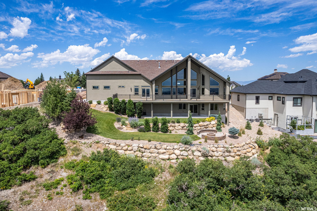 Rear view of house featuring balcony and a patio
