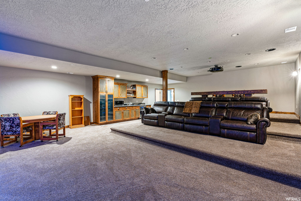Carpeted living room featuring a textured ceiling
