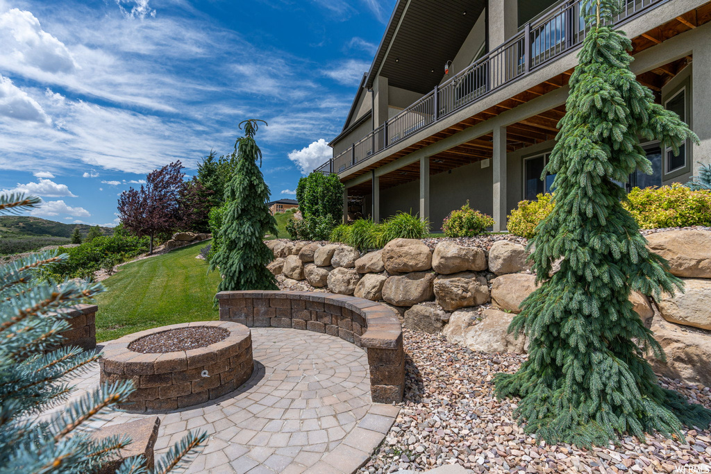 View of patio / terrace with a firepit and balcony
