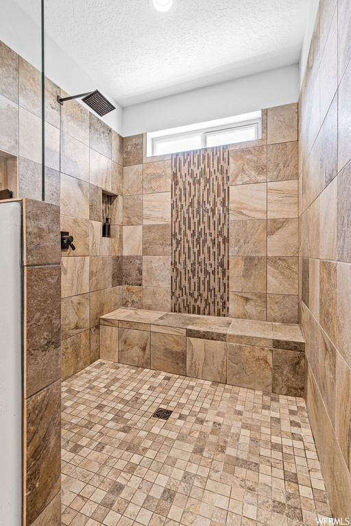 Bathroom featuring a textured ceiling and tiled shower