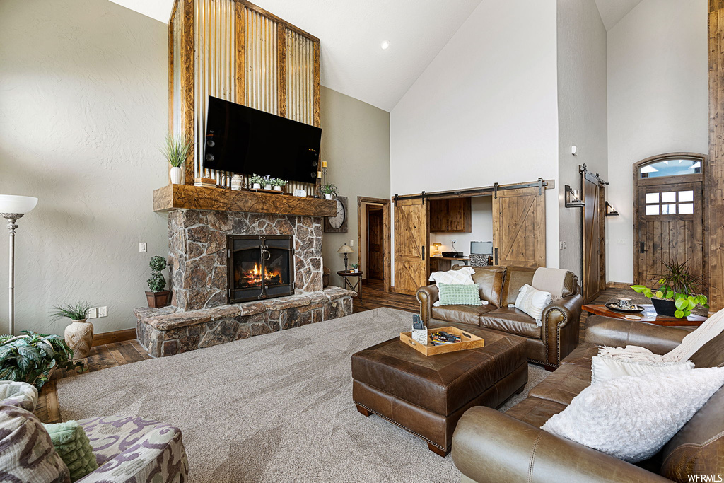 Carpeted living room with lofted ceiling, a fireplace, and a high ceiling