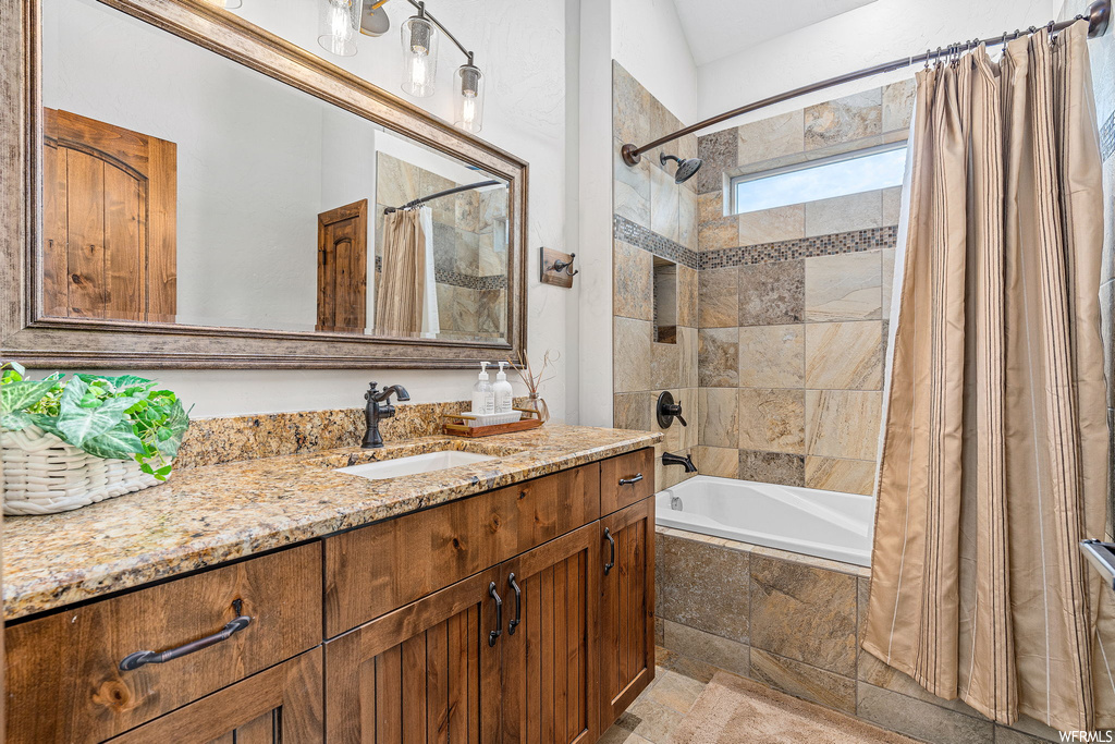 Bathroom with vanity, tile floors, mirror, and shower / tub combo with curtain