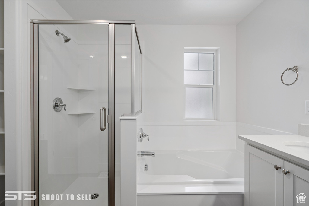 Bathroom featuring shower with separate bathtub and vanity