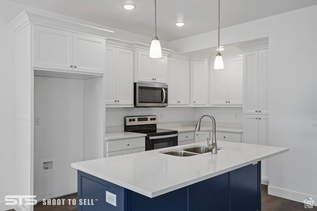 Kitchen featuring pendant lighting, dark hardwood / wood-style flooring, appliances with stainless steel finishes, white cabinets, and sink