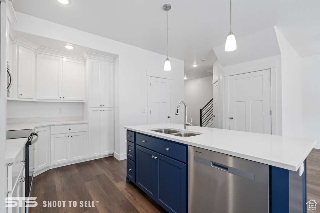 Kitchen featuring decorative light fixtures, white cabinets, appliances with stainless steel finishes, sink, and dark hardwood / wood-style floors