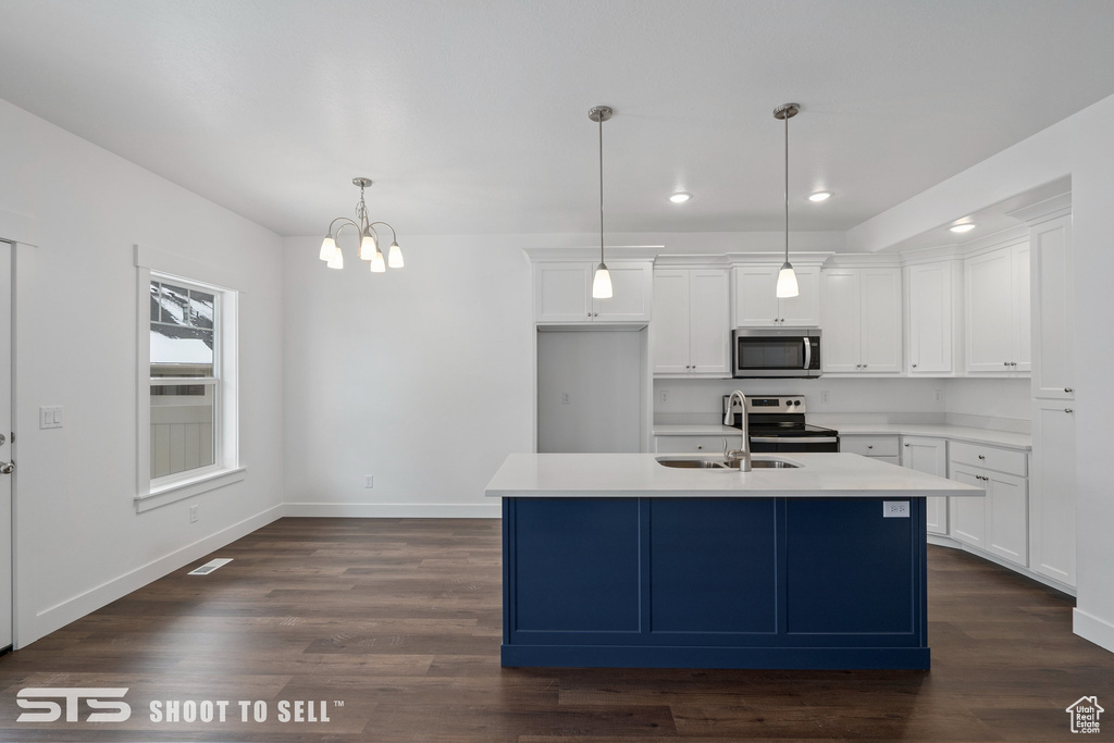 Kitchen featuring stainless steel appliances, dark wood-type flooring, and white cabinetry