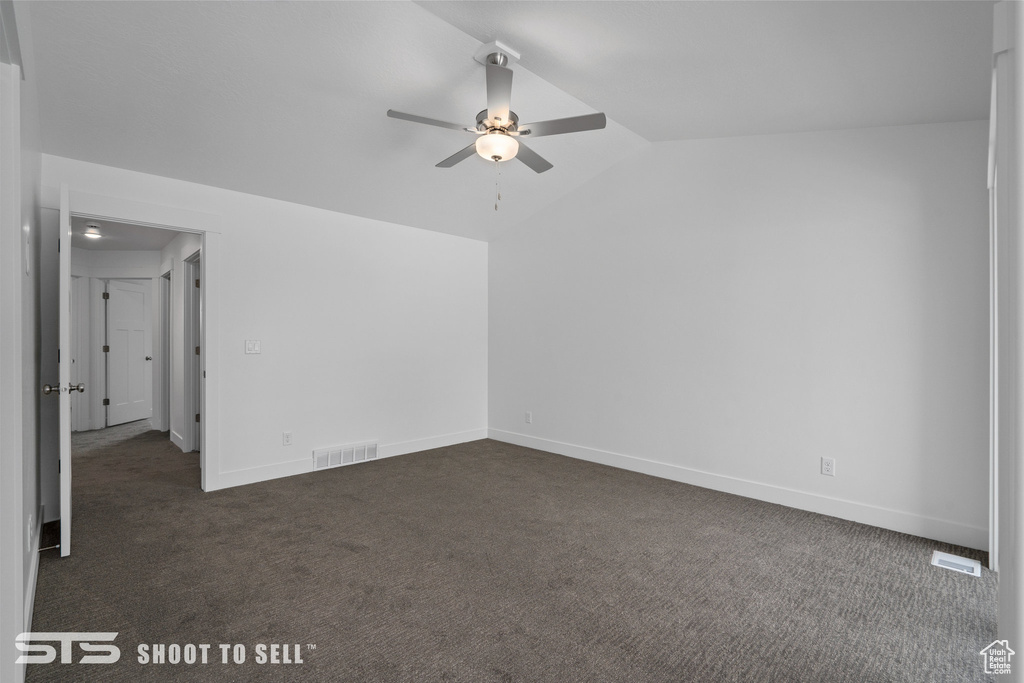 Unfurnished room featuring vaulted ceiling, dark carpet, and ceiling fan