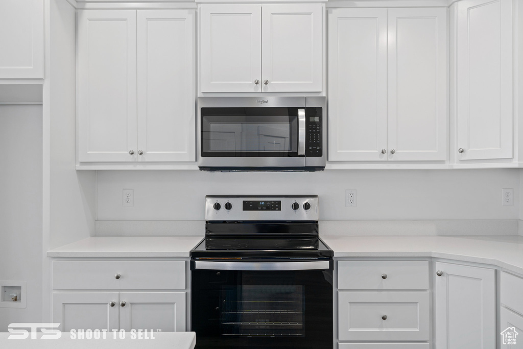 Kitchen featuring stainless steel appliances and white cabinetry