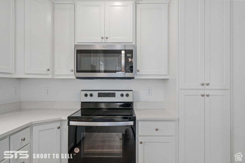 Kitchen featuring appliances with stainless steel finishes and white cabinetry