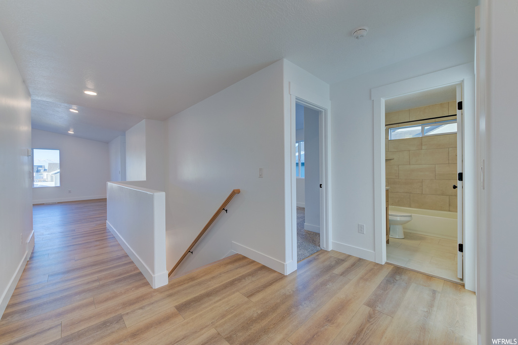 Hall with light hardwood / wood-style flooring
