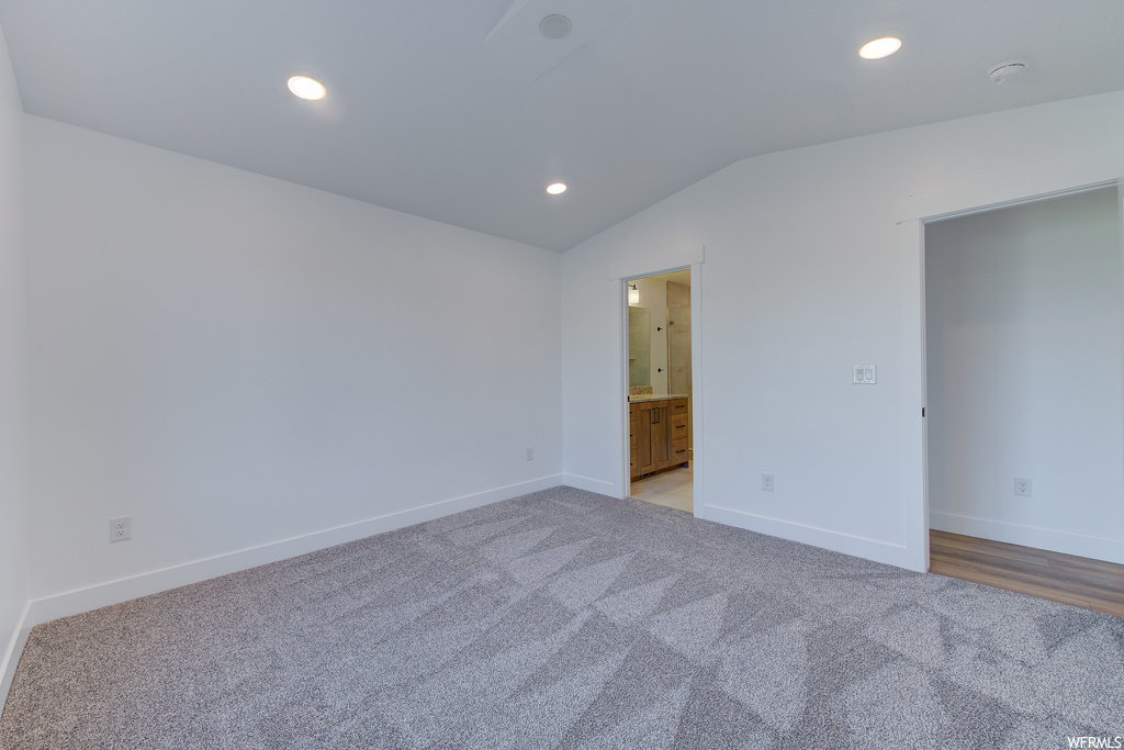 Spare room featuring lofted ceiling and light colored carpet