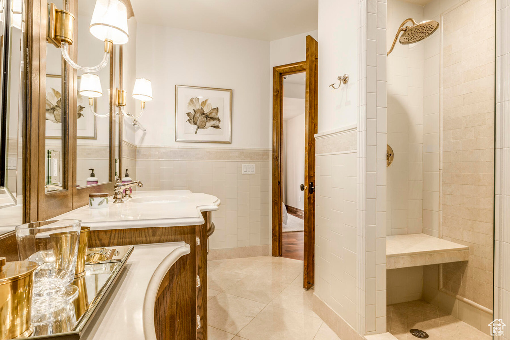 Bathroom with tile walls, a tile shower, tile flooring, and oversized vanity