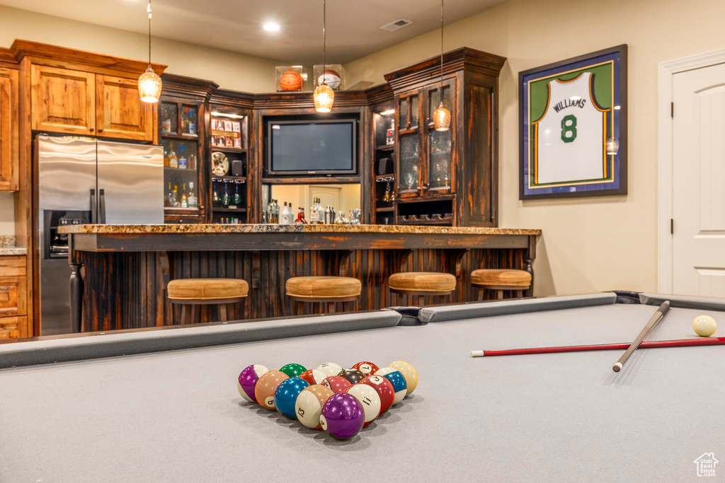 Interior space featuring pool table, decorative light fixtures, and stainless steel fridge