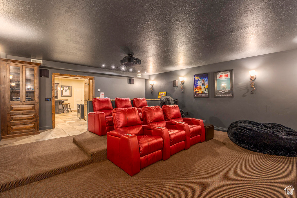 Home theater room with a textured ceiling and light tile floors
