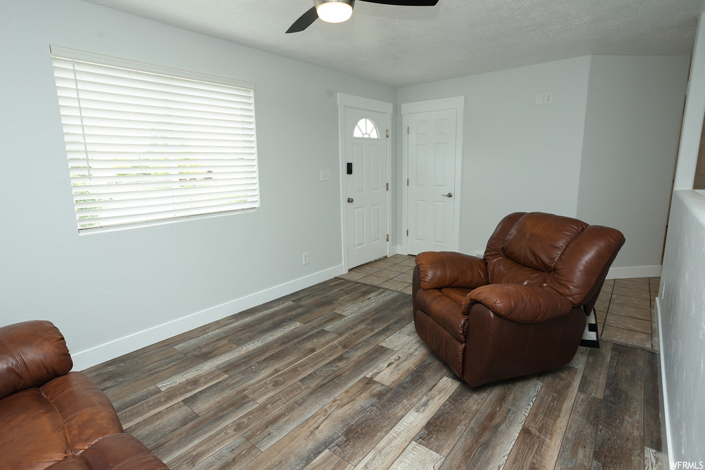 Living area with ceiling fan and hardwood floors