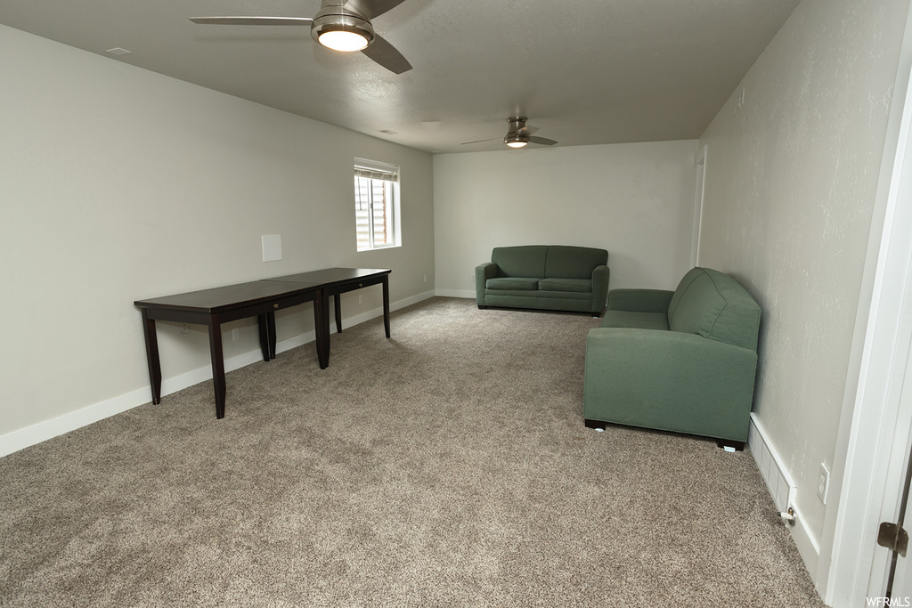 Sitting room with ceiling fan and light carpet