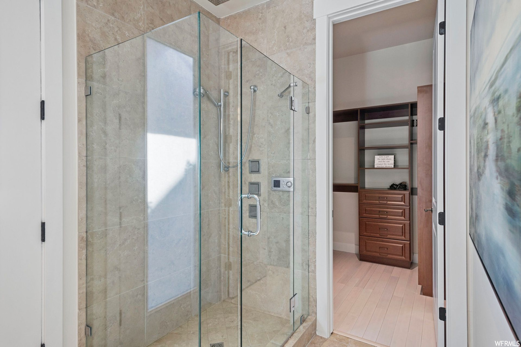 Bathroom featuring light hardwood flooring and an enclosed shower