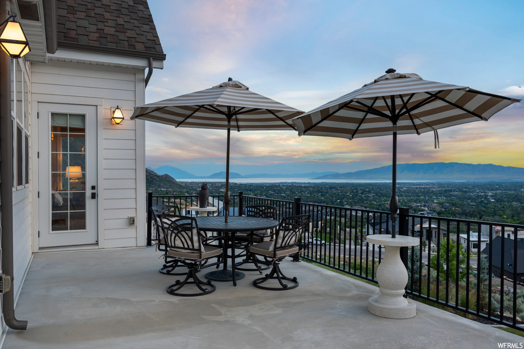 Patio terrace at dusk with balcony and a mountain view
