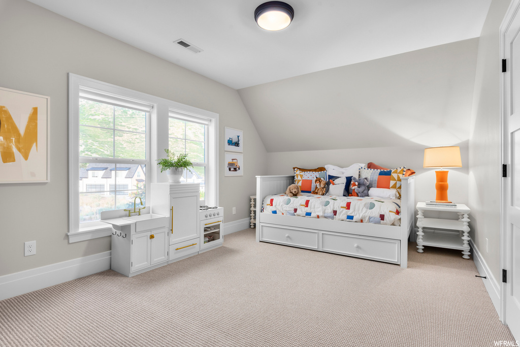 Carpeted bedroom with multiple windows and lofted ceiling