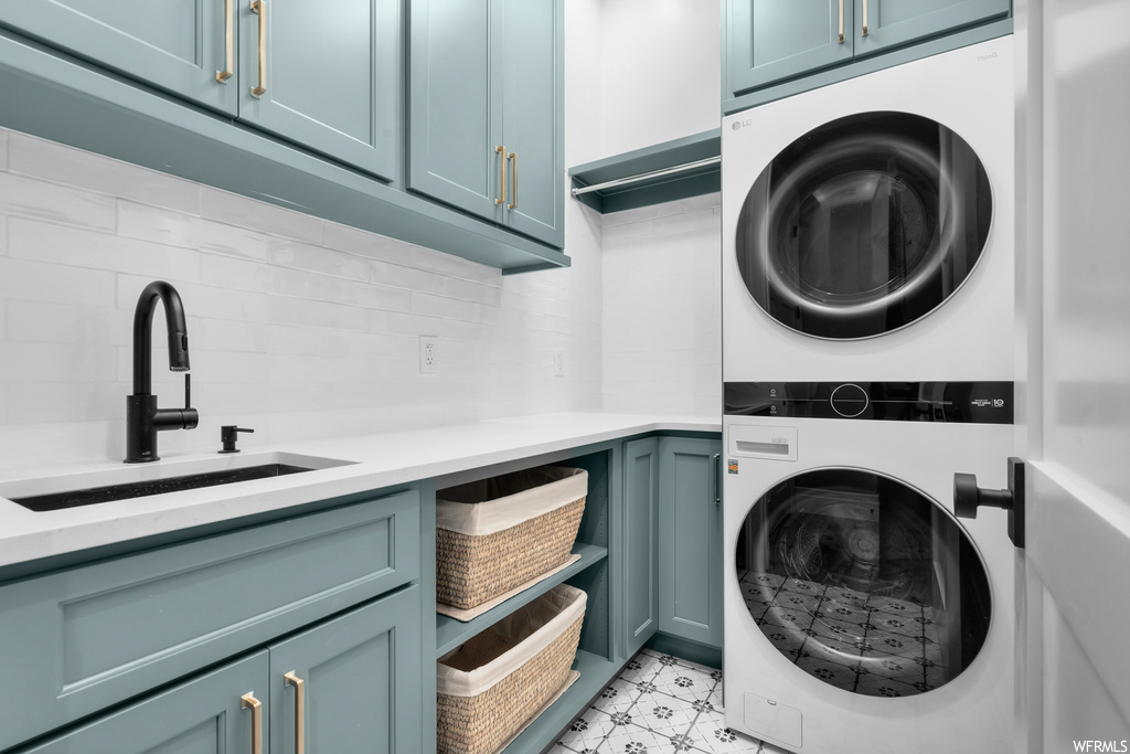 Laundry room featuring stacked washer / drying machine and light tile floors