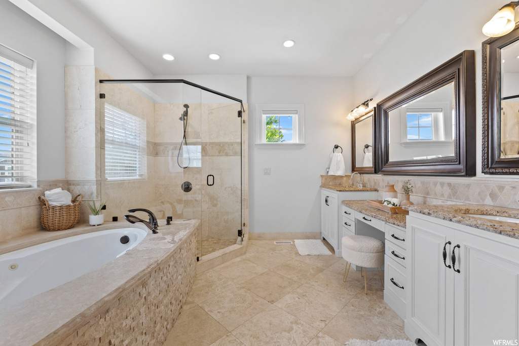 Bathroom featuring mirror, shower with separate bathtub, vanity, backsplash, and light tile floors