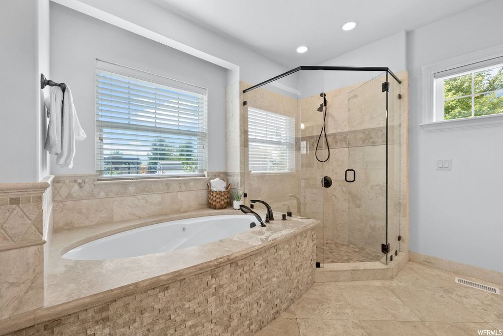Bathroom featuring light tile floors and separate shower and tub enclosures