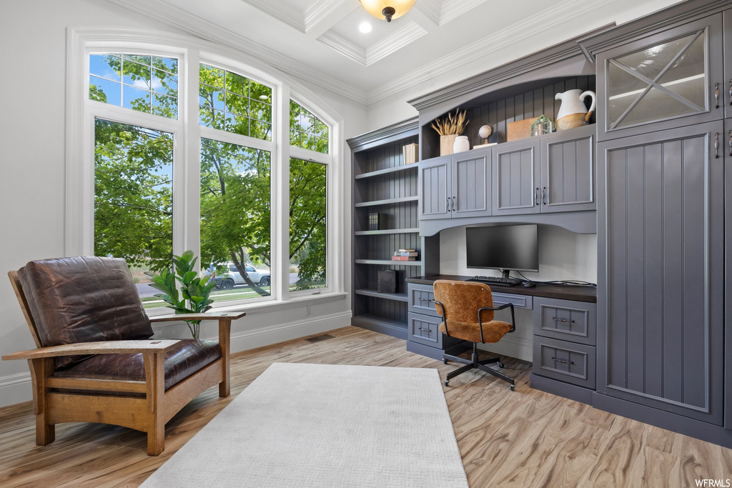 Wood floored home office with ornamental molding, beamed ceiling, and coffered ceiling