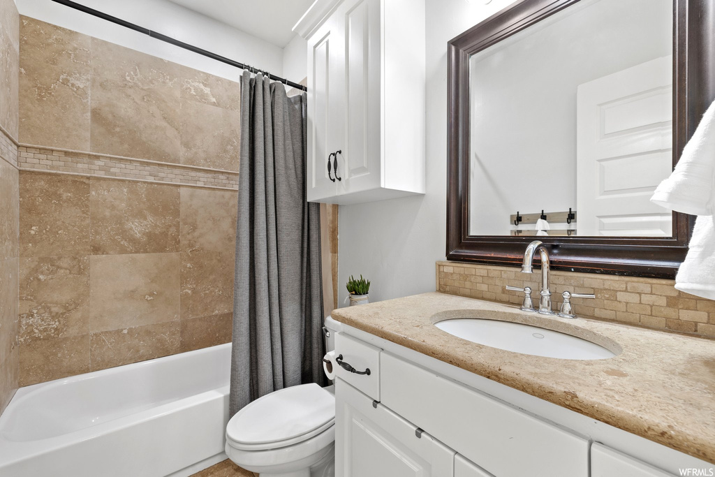 Full bathroom featuring backsplash, shower / tub combo with curtain, oversized vanity, and mirror
