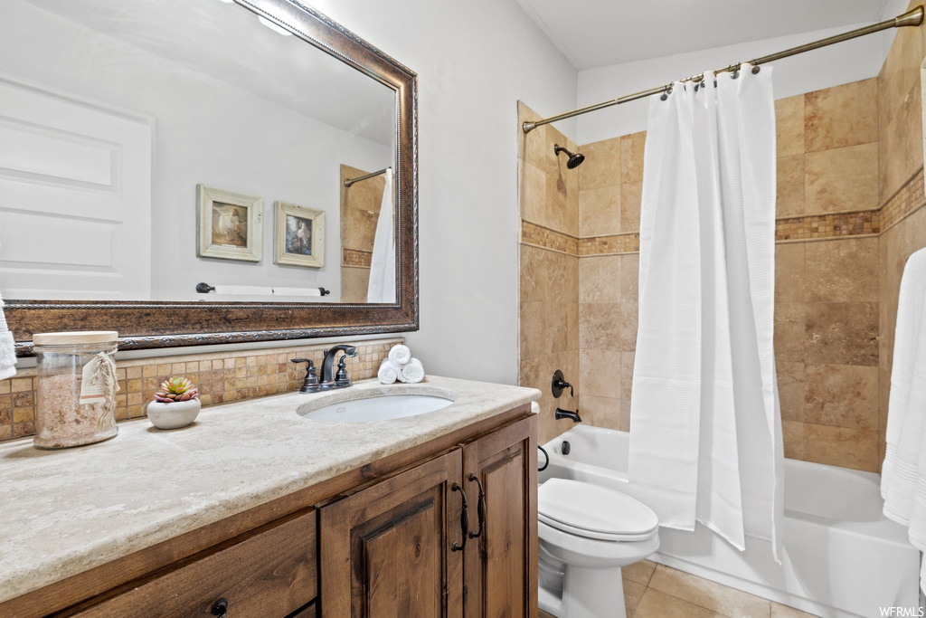 Full bathroom with light tile flooring, mirror, vanity, backsplash, and shower / bathtub combination with curtain