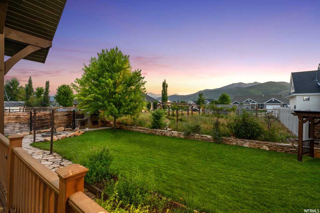 Yard at dusk with a mountain view and a patio area