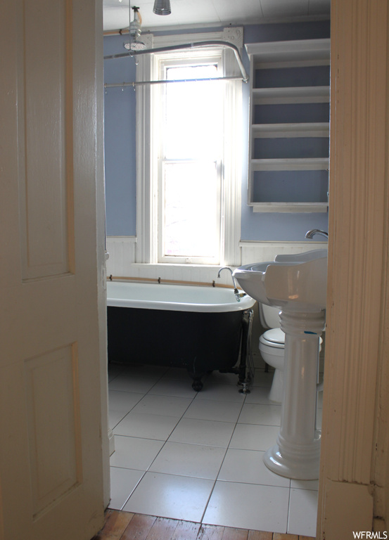 Bathroom featuring sink, ornate columns, a bathtub, tile flooring, and toilet