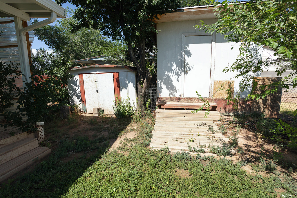 View of yard featuring a storage unit and a deck