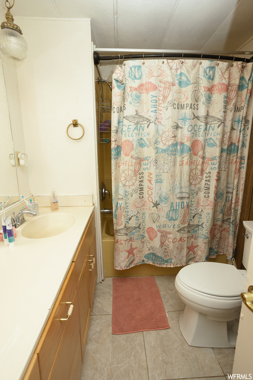 Full bathroom with vanity, shower / bath combo, mirror, and light tile floors