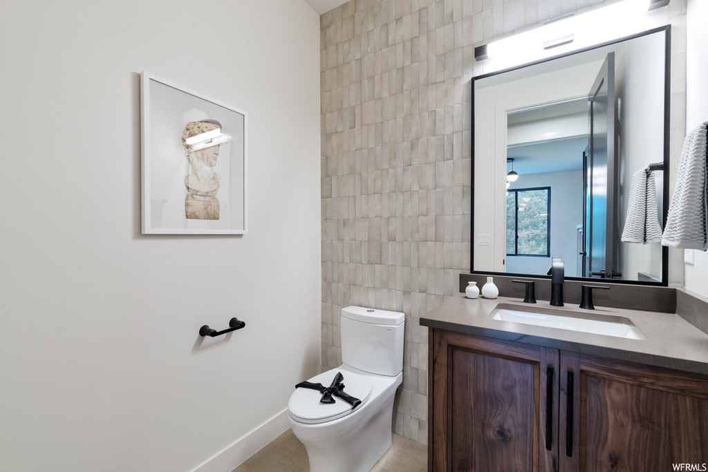 Bathroom with large vanity, tile walls, and mirror