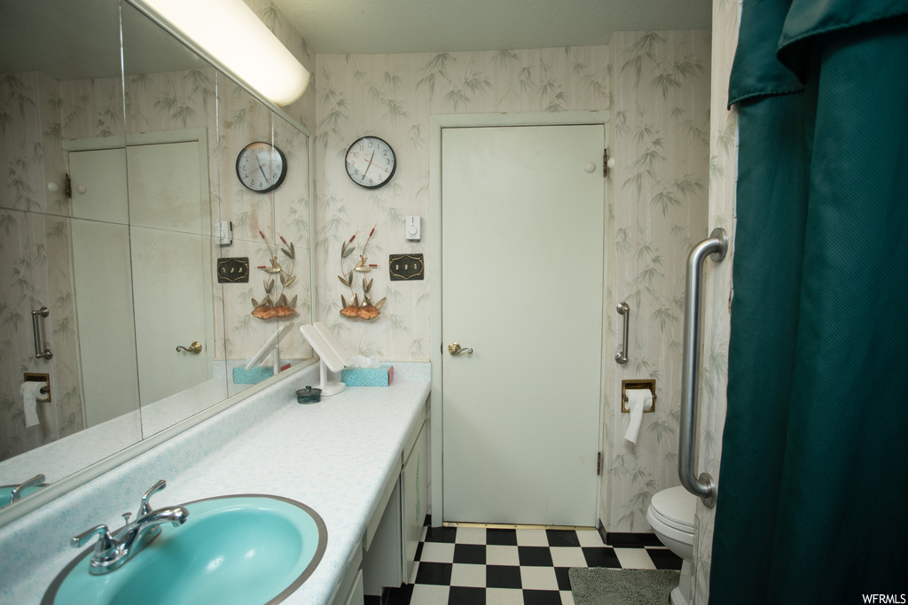 Bathroom featuring vanity, light tile flooring, and mirror