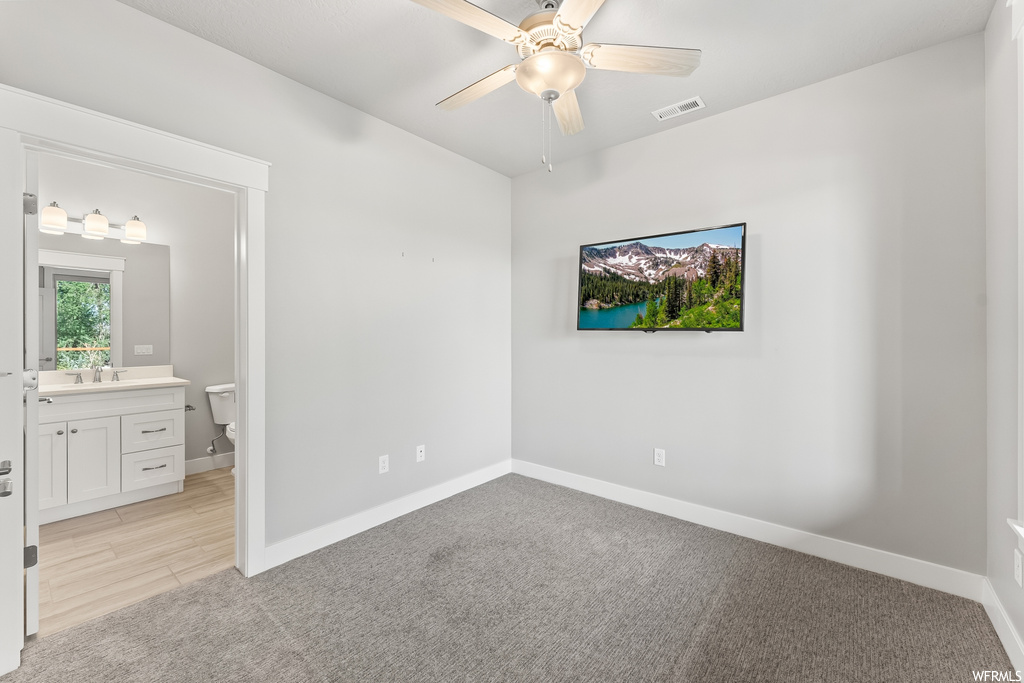 Carpeted bedroom featuring ceiling fan