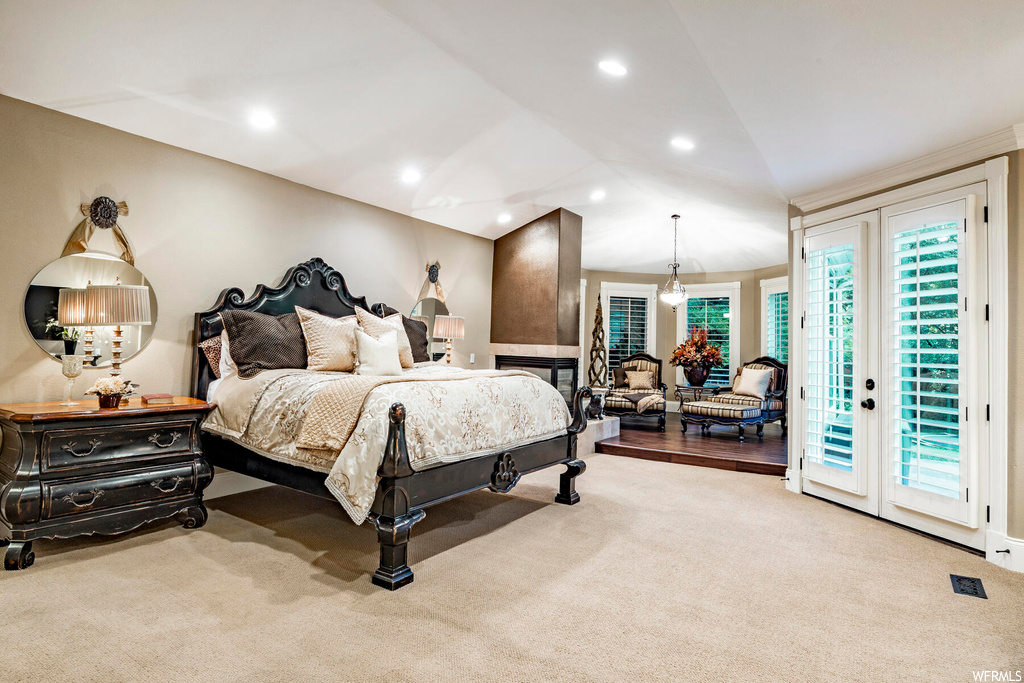 Carpeted bedroom with lofted ceiling and french doors