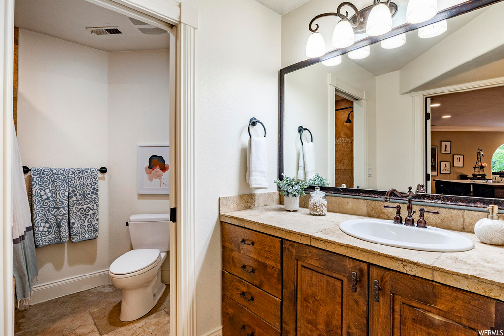 Bathroom with tile floors, ornamental molding, vanity with extensive cabinet space, and mirror