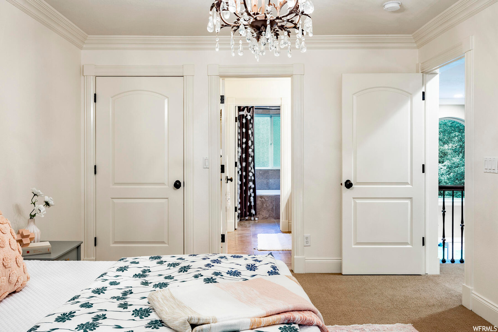 Bedroom featuring crown molding, light carpet, multiple windows, and a chandelier