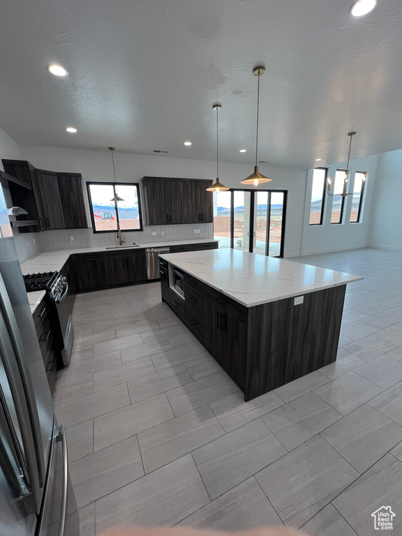 Kitchen featuring plenty of natural light, light tile floors, and a center island