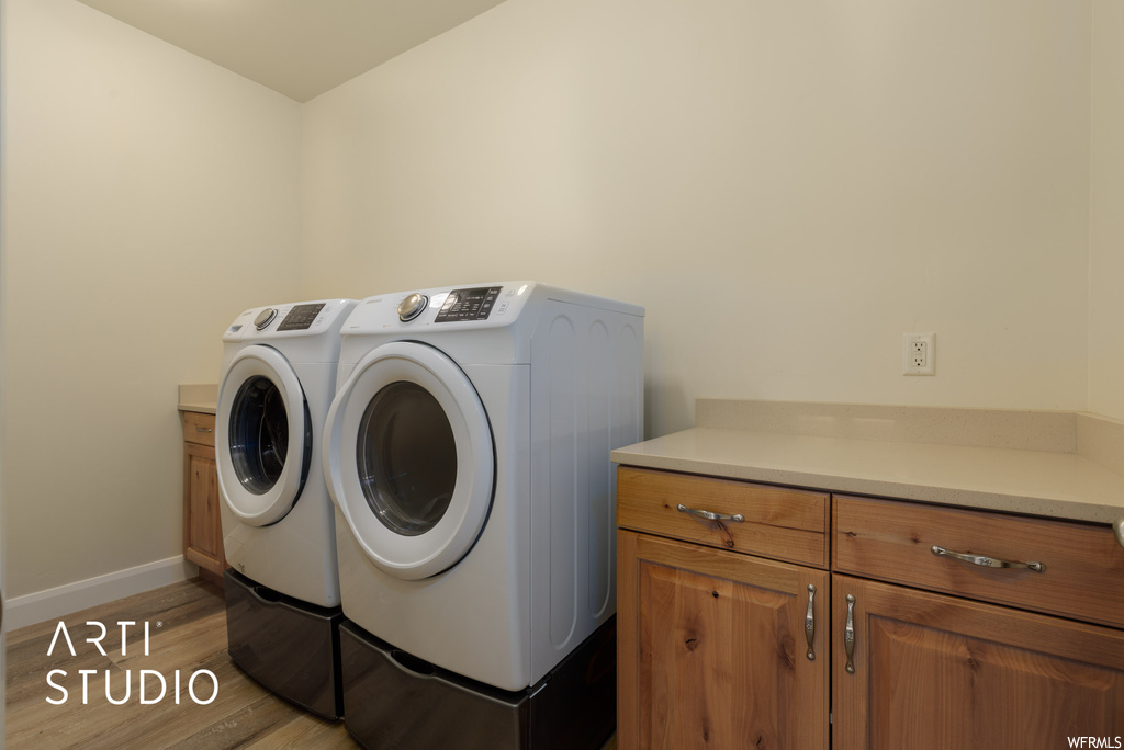 Clothes washing area with washing machine and dryer and hardwood floors