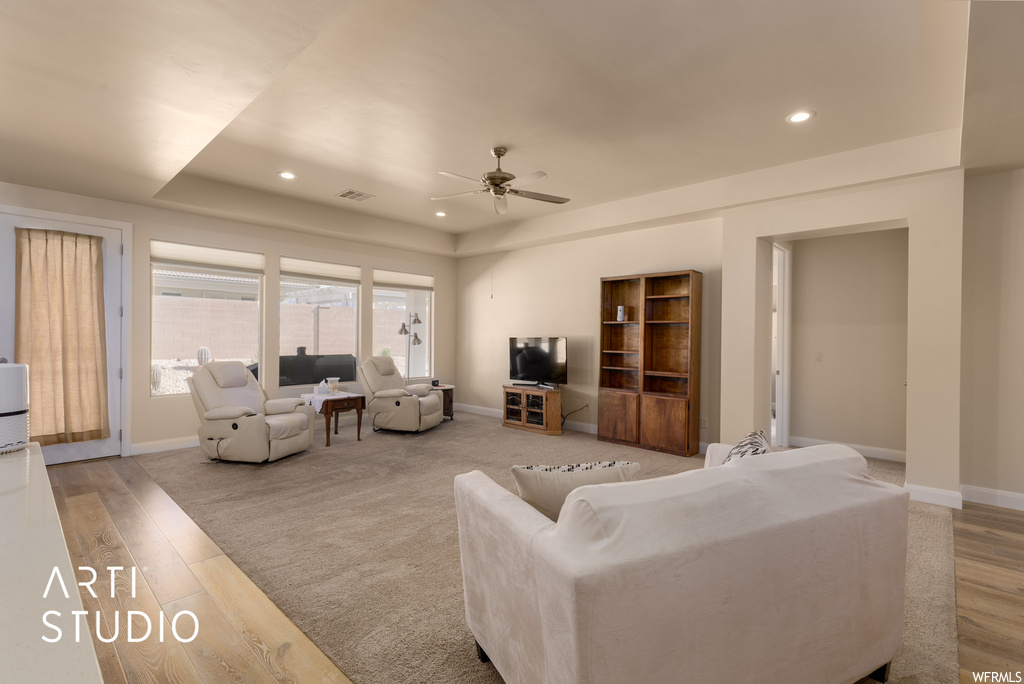 Hardwood floored living room featuring ceiling fan