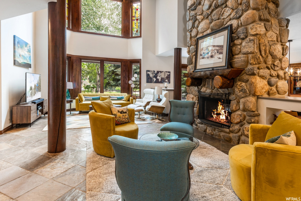 Tiled living room with a fireplace and a high ceiling