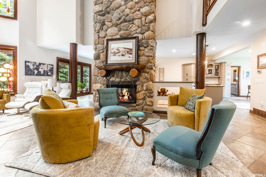 Living room with light tile floors, a wealth of natural light, and a fireplace