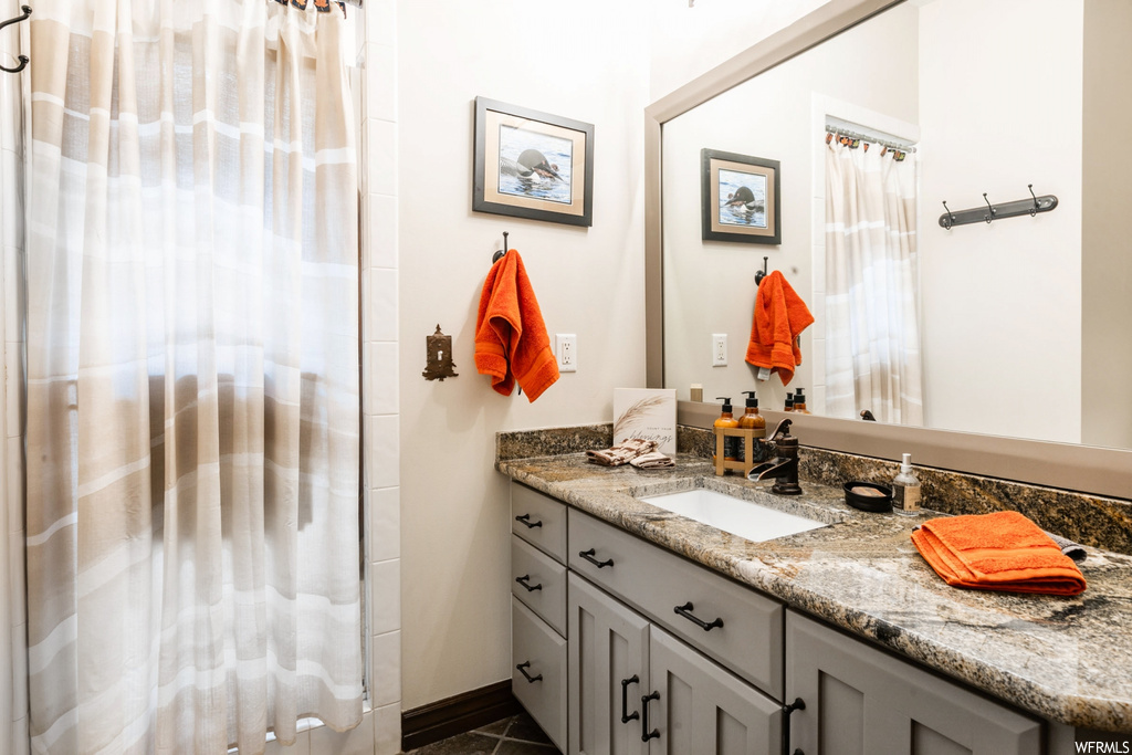 Bathroom featuring vanity, tile floors, and mirror