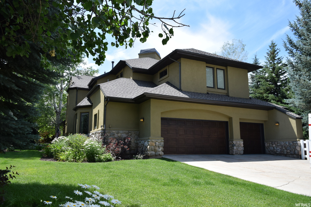 View of front of house featuring garage and a front yard