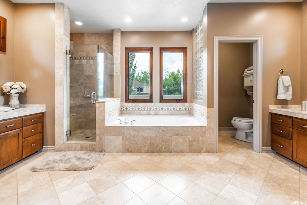 Full bathroom with vanity, separate shower and tub, and light tile floors